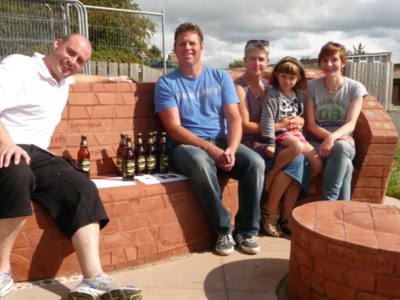 Completed bench with Stuart Dicken brick layer, Monty from Shropshire Radio, Ruth brick artists and daughter Jess with Cait Leach project manager
