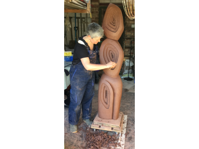 Carving garden sculpture in raw brick clay