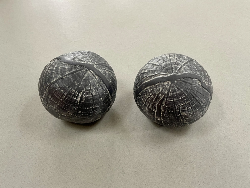 Stoneware spheres embossed with tree prints, decorated with porcelain slip and human ash. Ash contained within